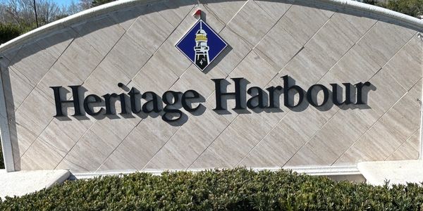 Entrance sign for Heritage Harbour with a lighthouse logo.