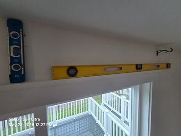 Two spirit levels placed above a window.