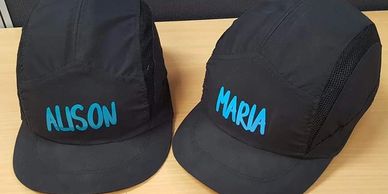 Black safety hat personalised with names in blue vinyl.