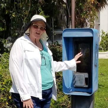 Author standing beside old land line phone booth looking confused, reflecting on being 50 years old.