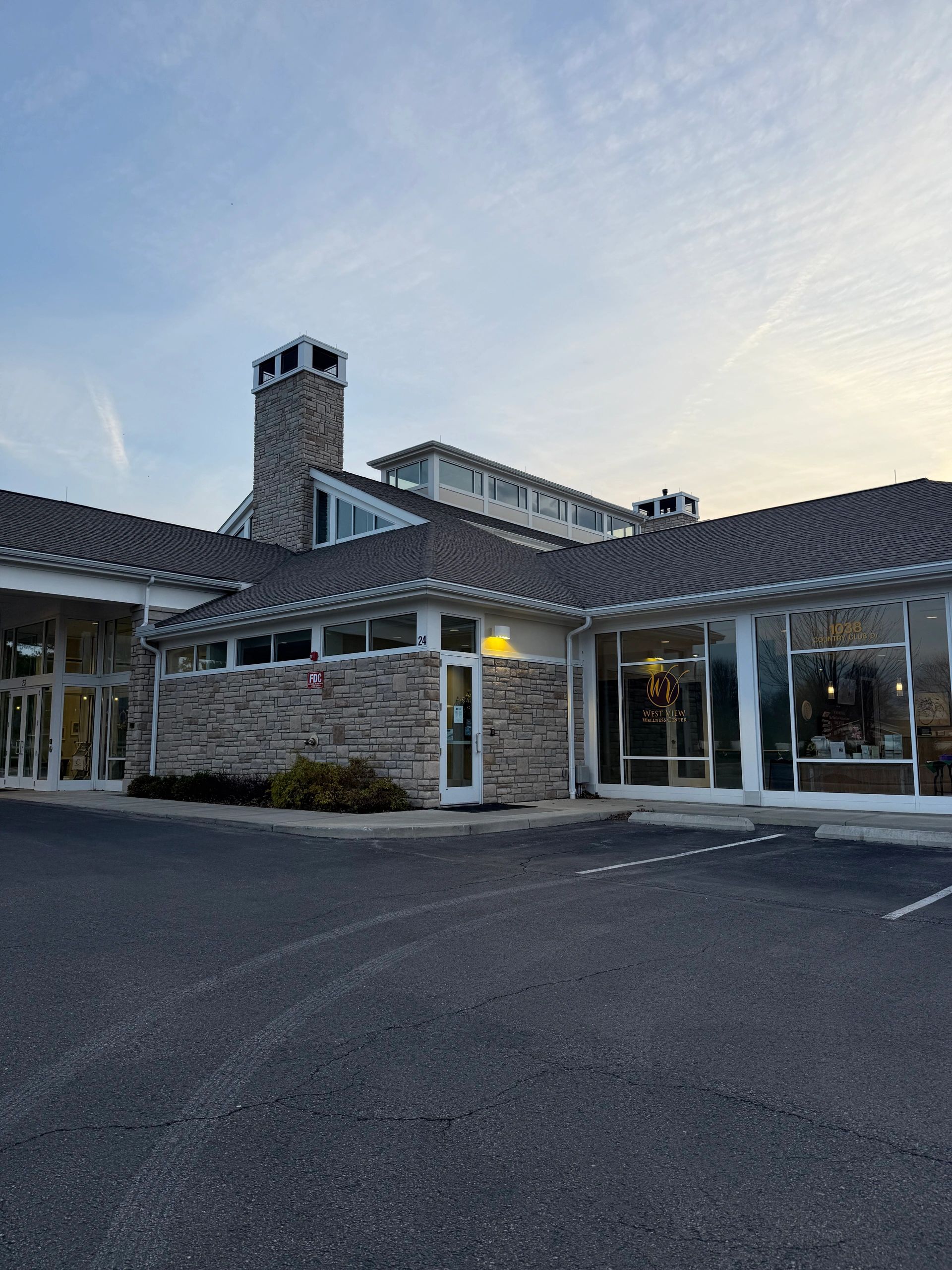 Exterior view of a wellness center building at dusk with clear skies.