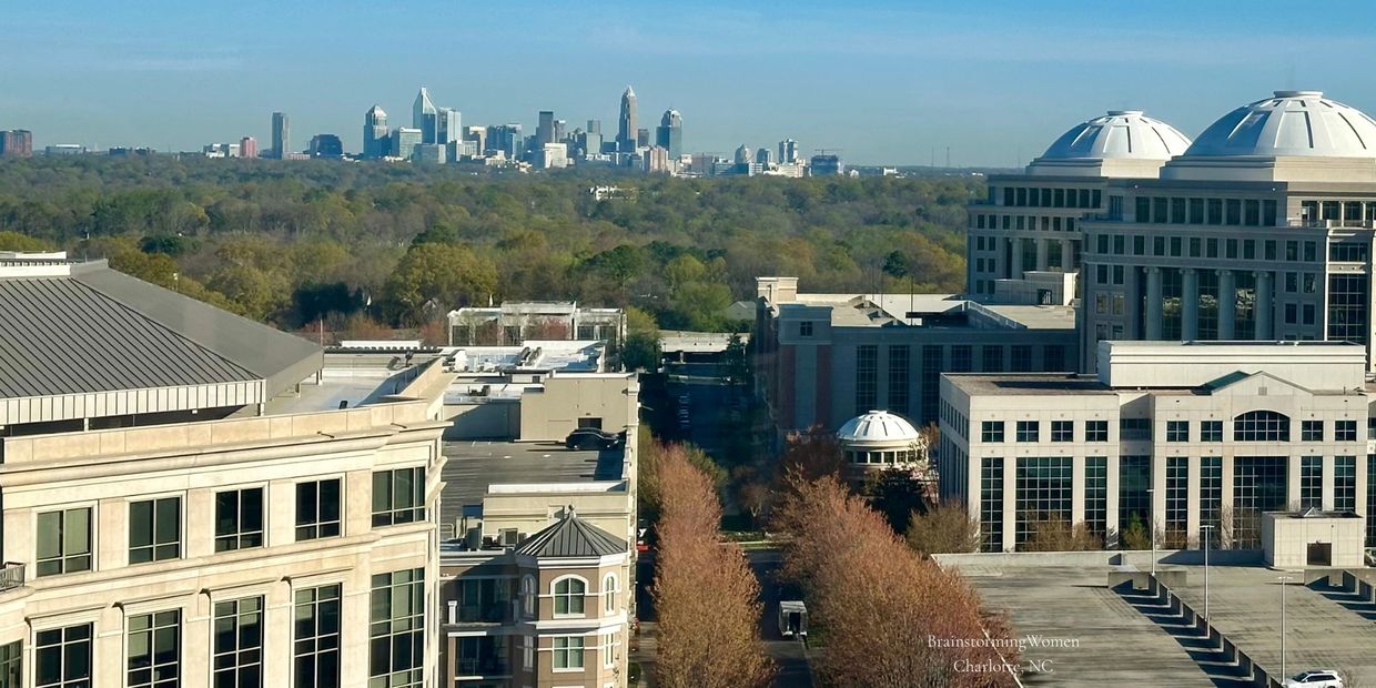 View of Charlotte, NC skyline with buildings and trees in autumn.