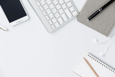 Organized workspace with phone, keyboard, and notebook.