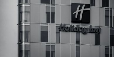 Black and white photo of a Holiday Inn building facade with modern glass windows.