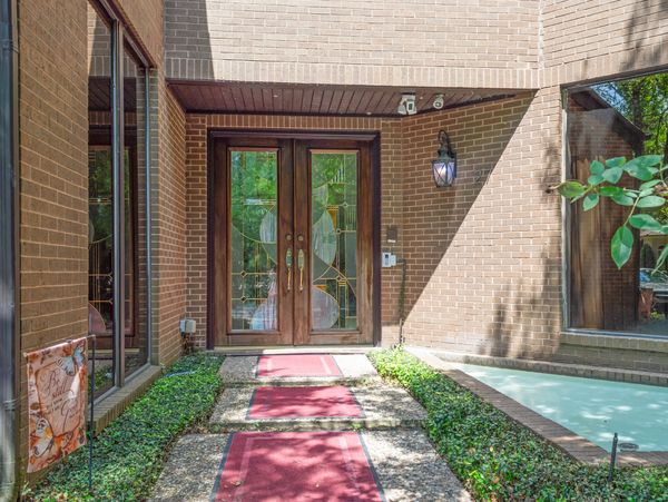 Brick home entrance with stained glass doors.