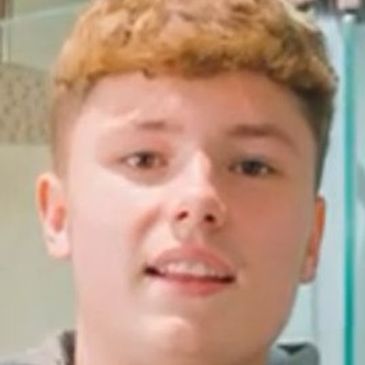Young man with short curly hair.