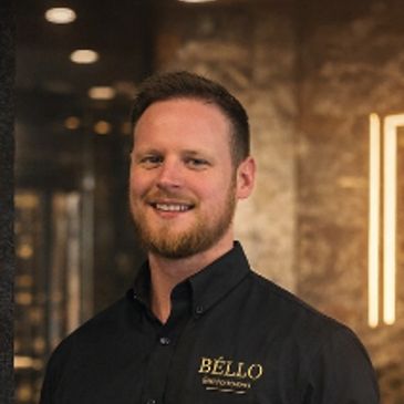Smiling man in a black Bello shirt.