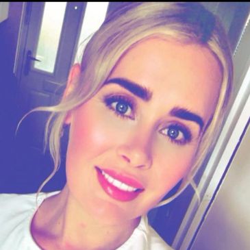 Smiling woman with blue eyes and blonde hair.