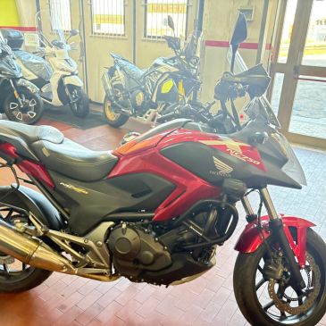Red Honda NC750 motorcycle displayed indoors.