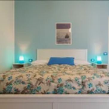 Cozy bedroom with floral bedding and blue accents.