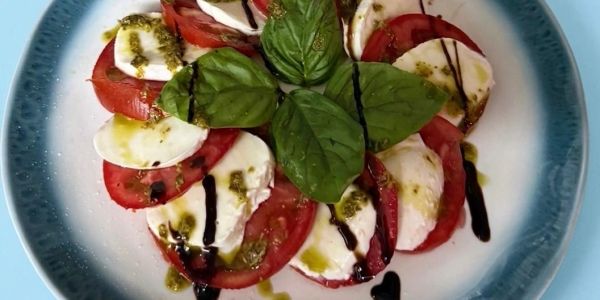 Caprese salad with tomatoes, mozzarella, basil, and balsamic glaze.