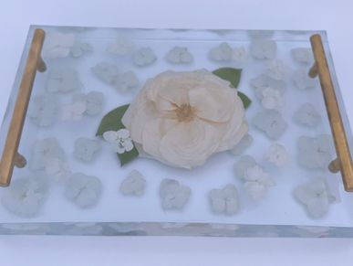 Preserved flowers in resin tray.