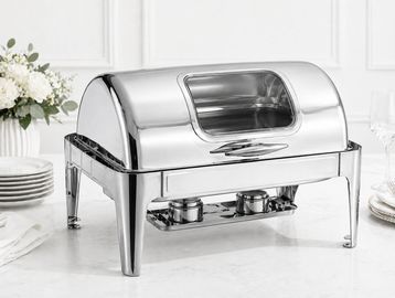 Shiny stainless steel chafing dish on a white marble table.