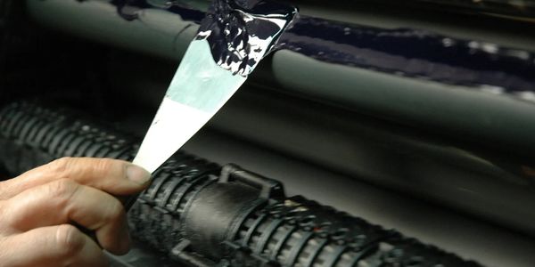 A pressman adds ink to offset machine.