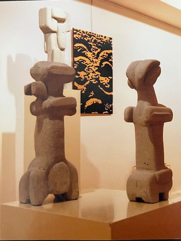 Abstract sculptures with a face artwork in the background.