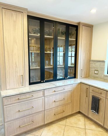 Modern kitchen cabinets with glass doors and gold handles.