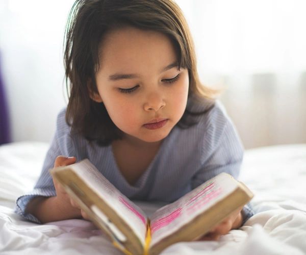 Preschool girl reading bible