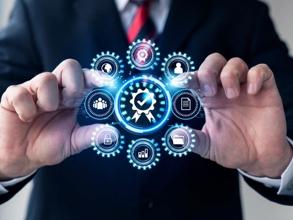 Businessman interacting with glowing digital quality assurance icons.