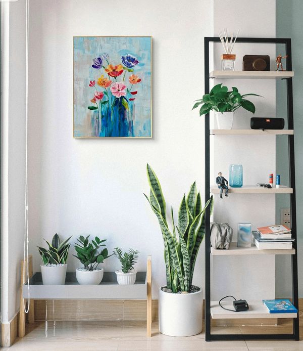 Bright room with plants, a colorful flower painting, and a black-framed shelf.