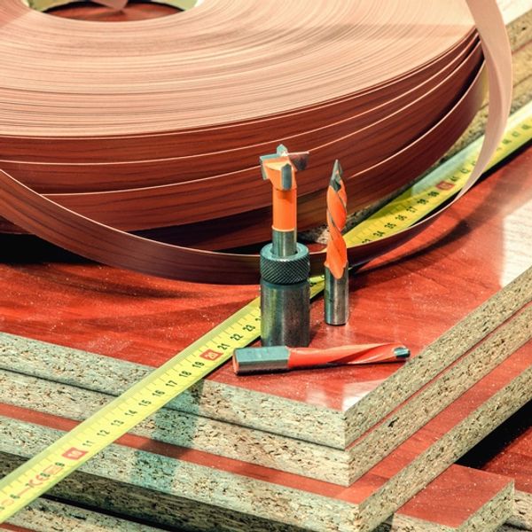 Woodworking tools and materials including drill bits, tape measure, and wood panels.