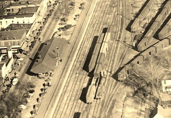 Aerial view of a train station with multiple tracks and freight cars.