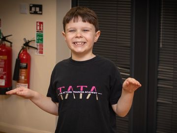 Junior Actors Smiling boy balancing his hands indoors.