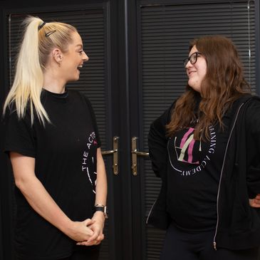 Senior Actor and class tutor laughing together.