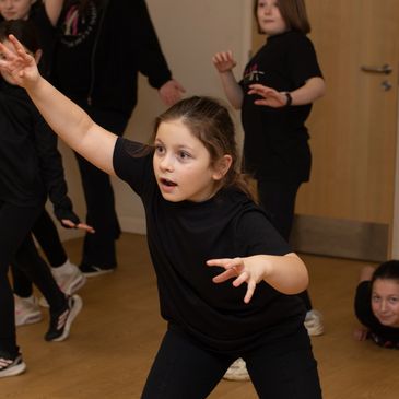 Junior Actor holding frozen image during drama exercise.