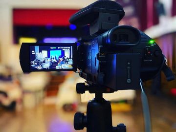 Video camera recording an event indoors.