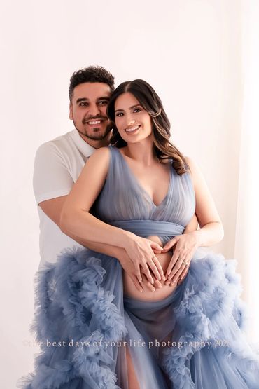 a pregnant woman in blue gown with her husband 