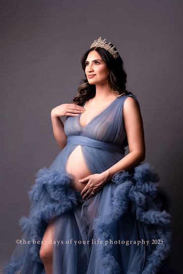 a pregnant woman in a blue gown with a tiara 