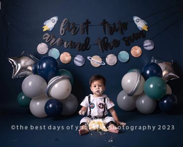 A small baby boy eating the cake with the blue background