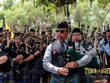 A group of men playing bagpipes in a parade.