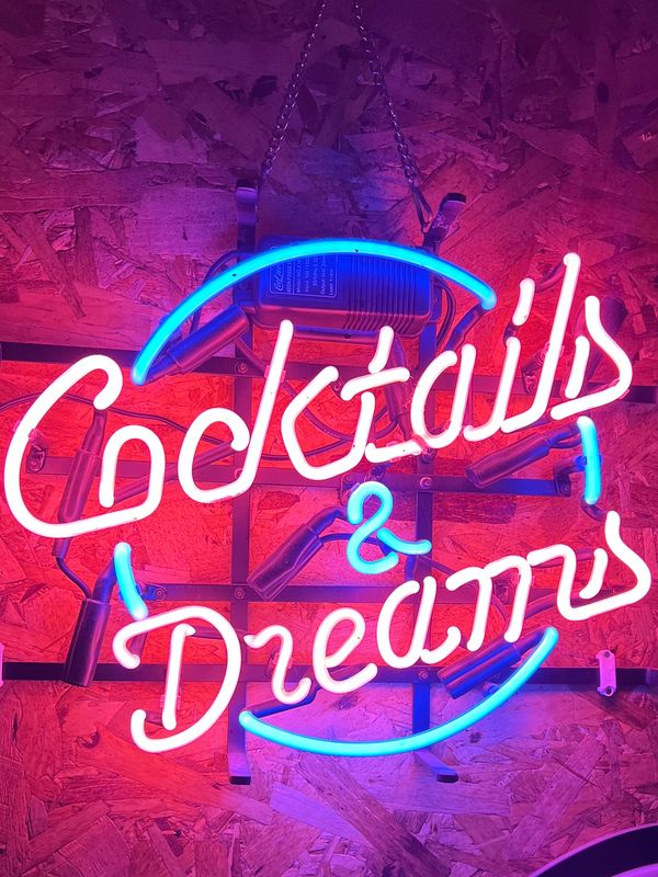 Neon sign saying 'Cocktails &amp; Dreams'.