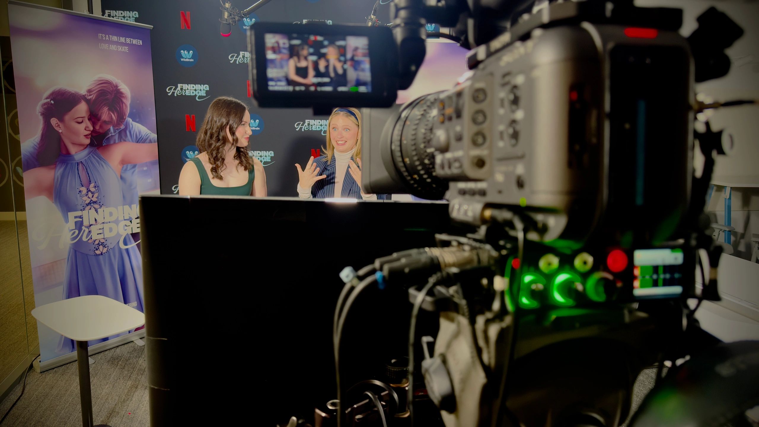 Two women being interviewed on camera for a Netflix series promotion.