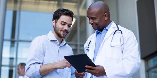 Doctor and patient discussing medical information on a tablet.