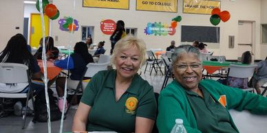 Two women smiling at a community event.
