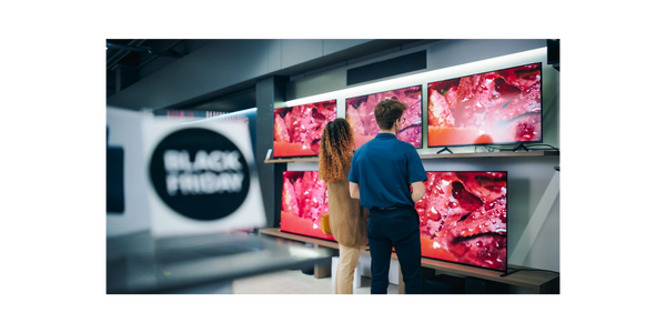 Two people viewing TVs with vibrant red images during a Black Friday sale.