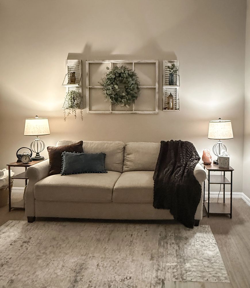 Cozy living room with beige sofa, soft cushions, and warm lighting.