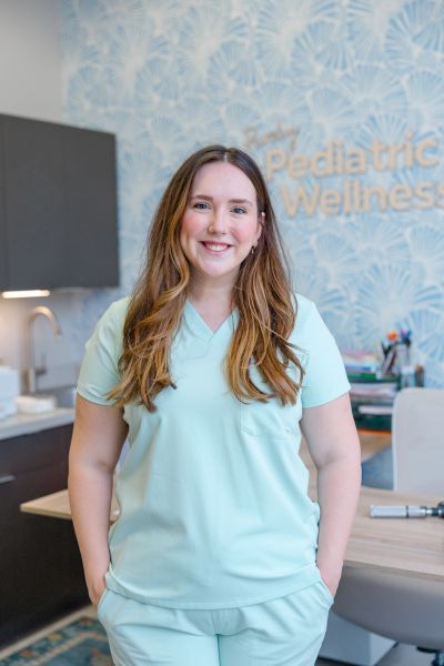 Smiling female healthcare worker in scrubs.