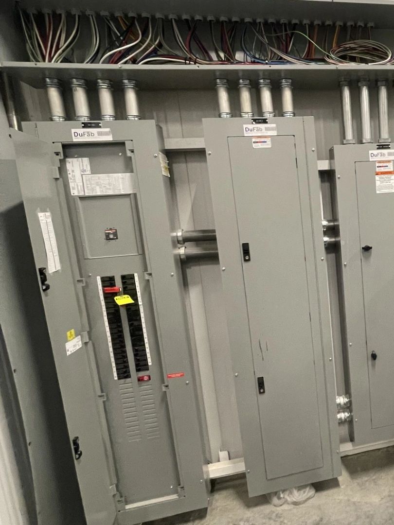 Electrical panel boxes with wiring above.