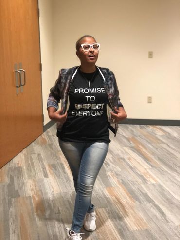 alt="Christian young woman wearing glasses and modeling a black Promise Principles t-shirt"