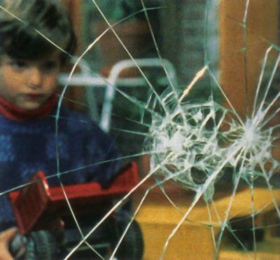 a boy playing with a broken window