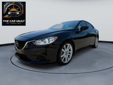 Sleek black Mazda sedan showcased on a rotating platform with The Car Vault logo.