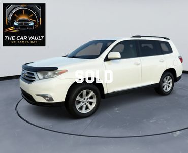 White Toyota Highlander SUV parked in a studio with 'SOLD' text overlay.