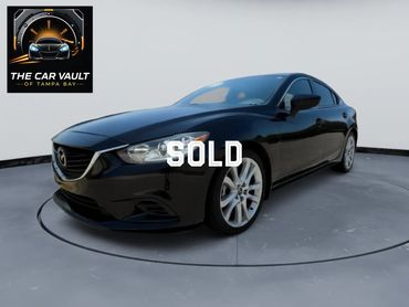 Sleek black Mazda sedan showcased on a rotating platform with The Car Vault logo.