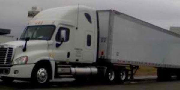 White semi-truck parked on a cloudy day.