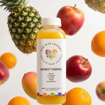 A bottle of Market Sunrise juice surrounded by fresh fruits like apples, pineapple, and oranges.