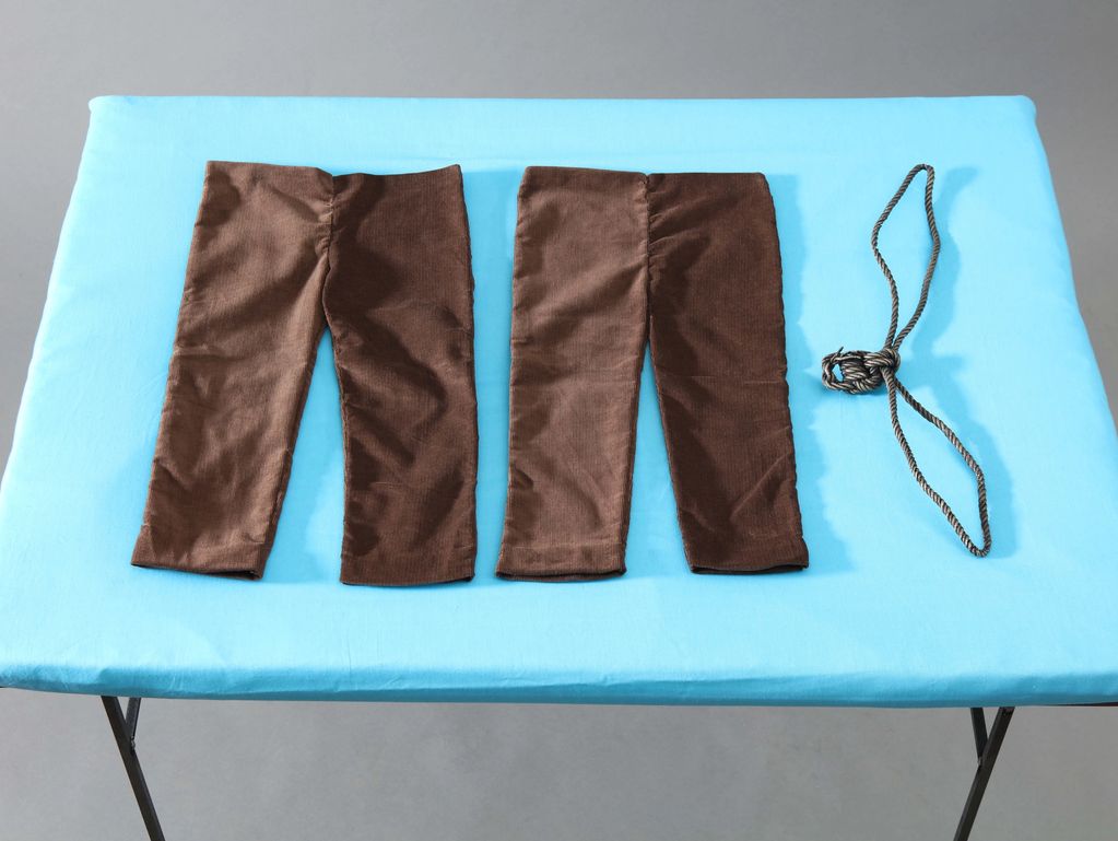 Two brown fabric sleeves and a rope on a blue surface.