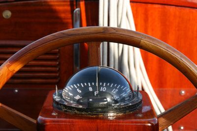 Bubble compass on red sailing vessel with wheel